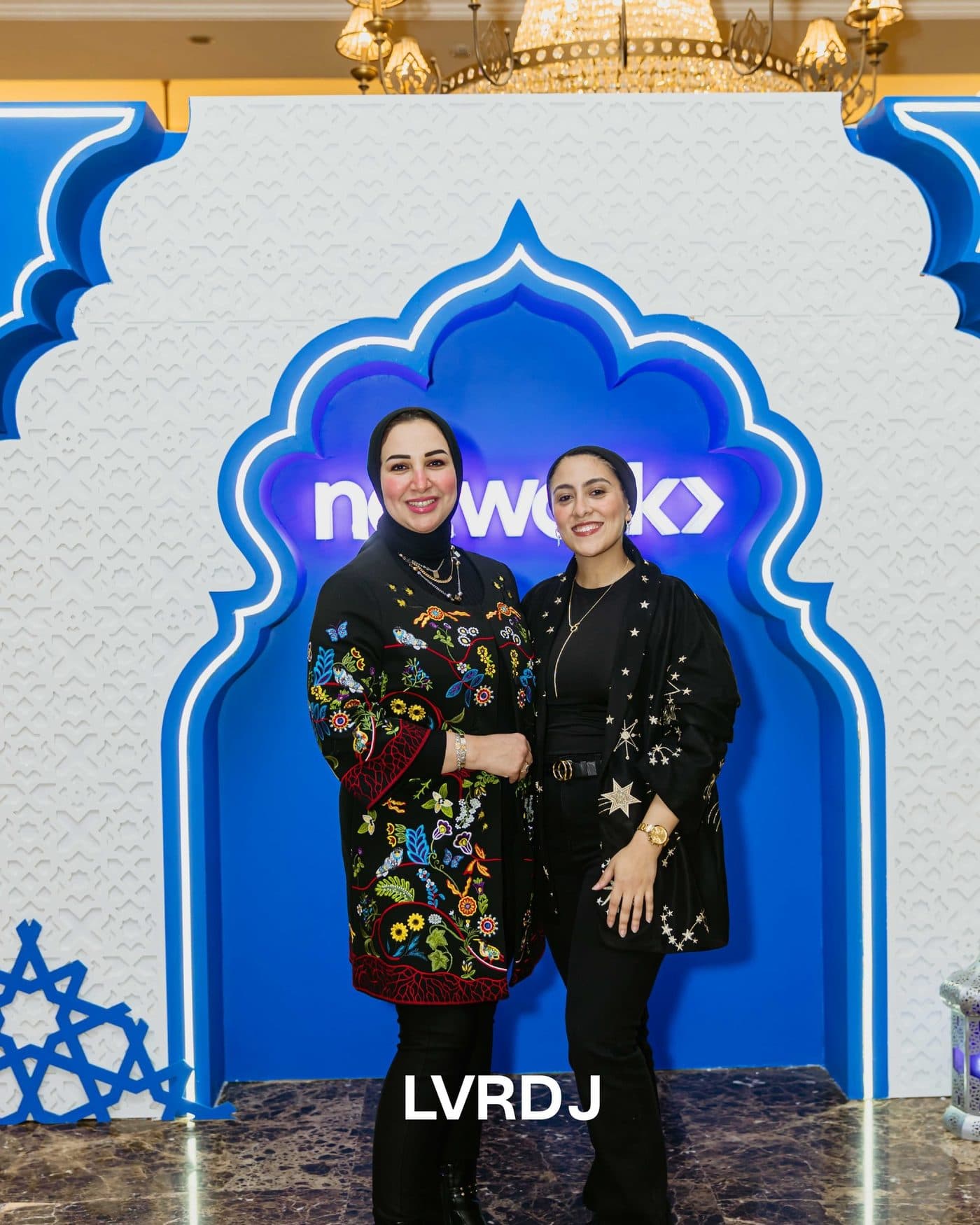 Guests posing under the blue Ramadan arch