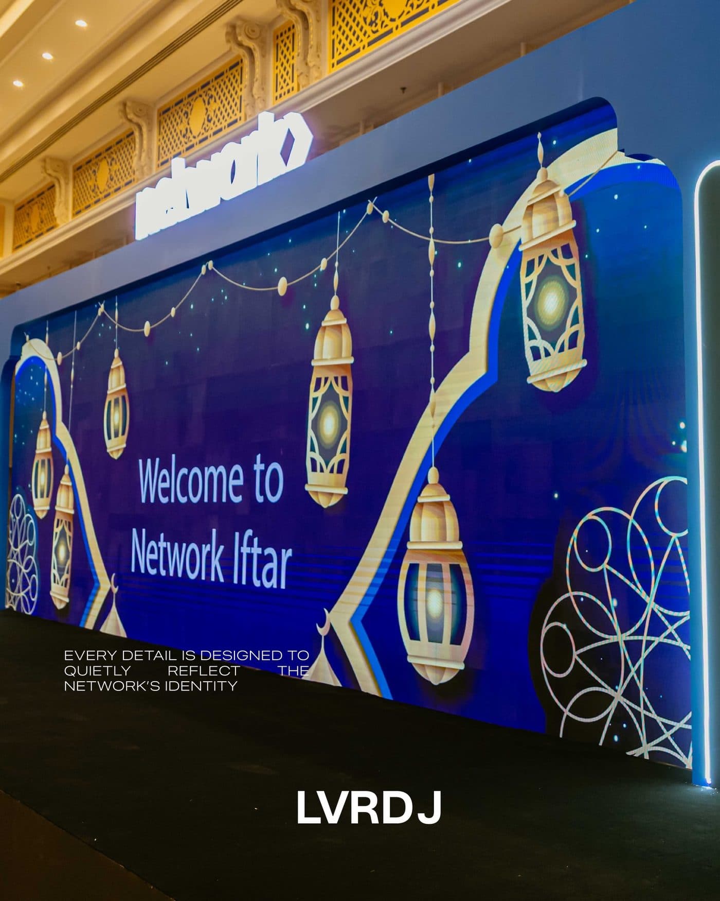 Blue 'Welcome to Network Iftar' wall with lanterns