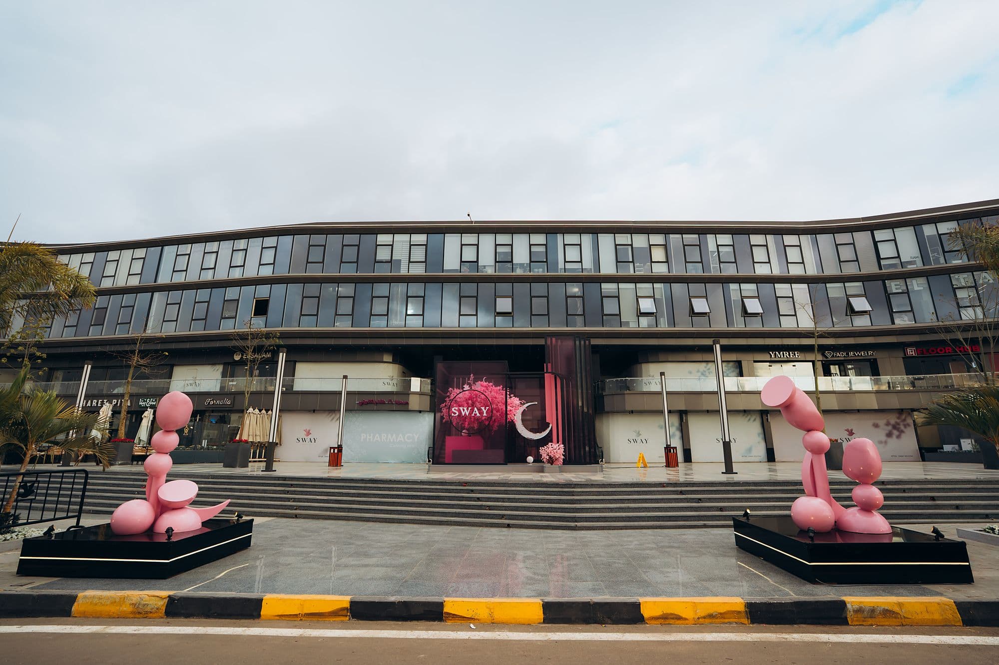 Wide SWAY façade with both pink sculptures in daylight